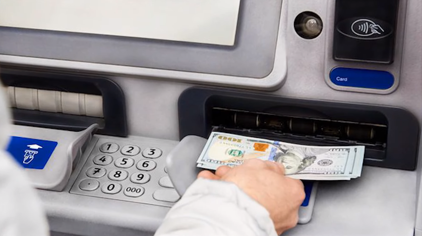 man making a cash deposit at an ATM
