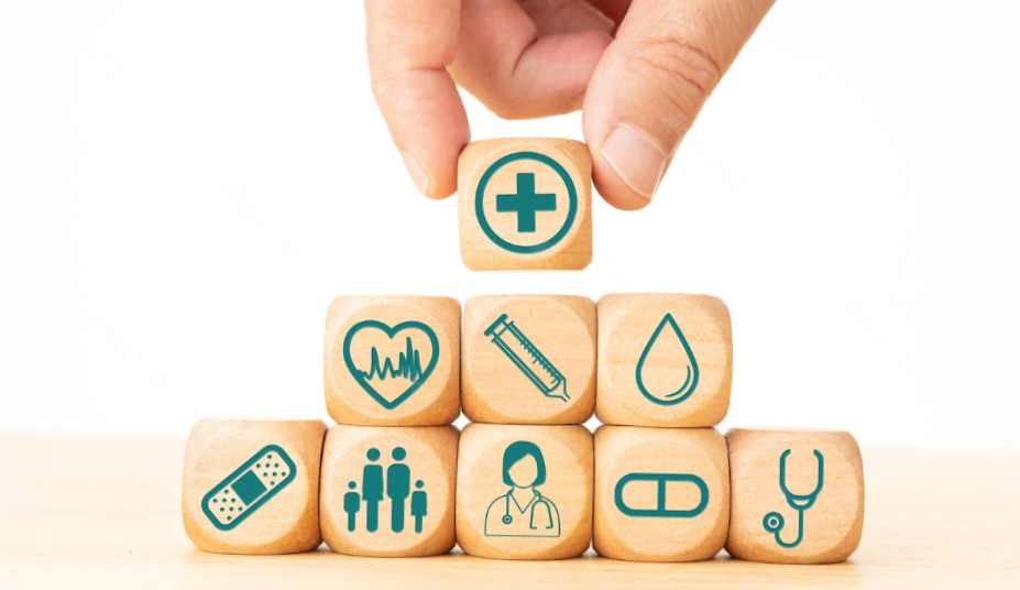 Health insurance concept wooden blocks with medical icons and hand holding a block with medical icon
