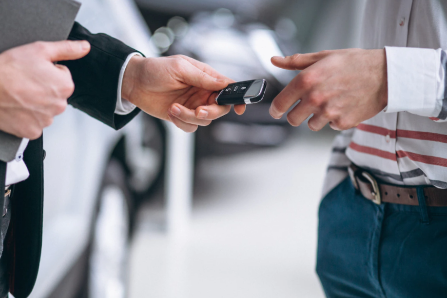 close up of man's hands giving car keys to another ones
