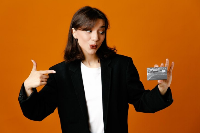 woman wearing a black jacket holding a Unique platinum credit card