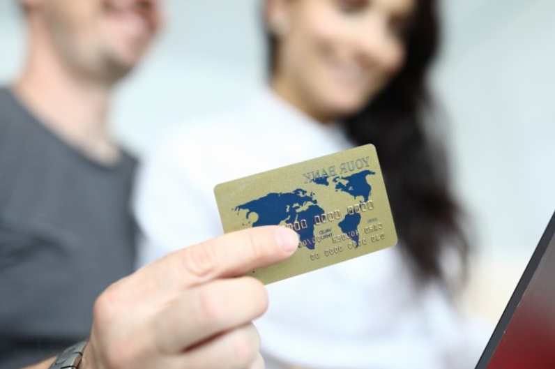 man and woman holding in hand credit card
