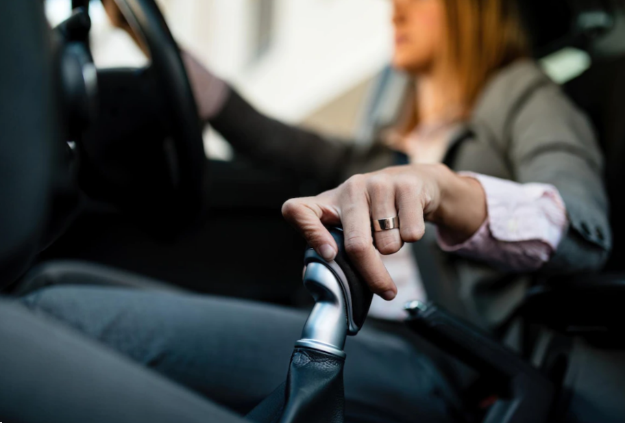Closeup of businesswoman driving car and shifting automatic transmission