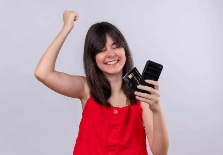  girl holding phone and credit card together white background
